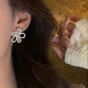 French style hollow flower pearl earrings in silver for women worn by a model