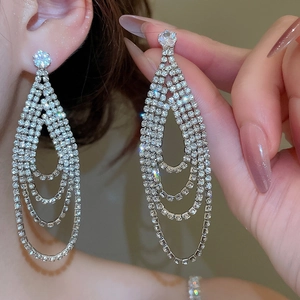 Gros plan sur les boucles d'oreilles pendantes à pampilles en strass argentés pour soirée