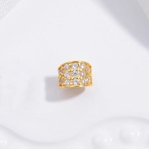 Close-up of a gold barrel bead with pavé-set zircons for DIY jewelry making