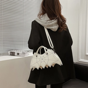 Rear view of a model wearing a white bat-shaped bag with spider web patterns and shoulder strap