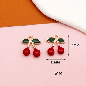 Détails macro des pendentifs cerises montrant les dimensions 15mm par 16mm et anneaux