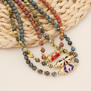 Detailed shot of beaded necklaces with colorful enamel charms and evil eye glass beads