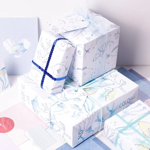 Ocean theme gift wrapping paper set with fish patterns and blue ribbons on boxes