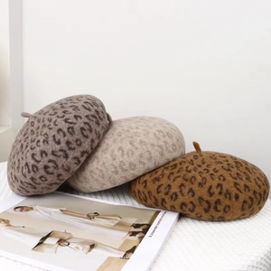 Detailed view of three leopard print wool berets in taupe, beige and caramel colors