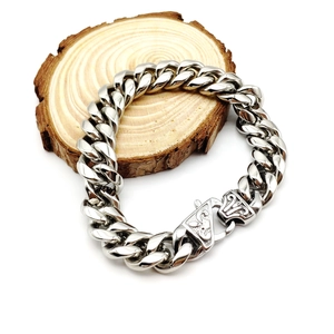 Polished silver stainless steel Cuban link bracelet with lobster clasp on a wooden base