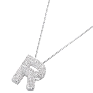 Macro shot of silver letter R pendant with sparkling cubic zirconia on a thin chain