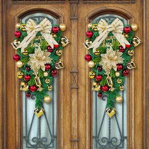 Christmas teardrop swag with gold ornaments and Merry Christmas sign on wooden door