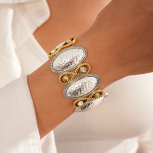 Close-up of geometric hollow cross bracelet with hammer-textured bicolor metal links