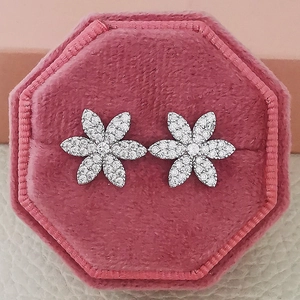 Macro view of crystal flower stud earrings set in a pink velvet jewelry box