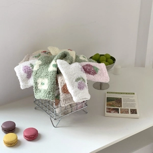 Detailed view of thick coral fleece winter socks with cute fruit and flower embroidery