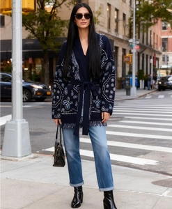 Detail view of dark blue knit cardigan with ethnic patterns and fringe hem decoration