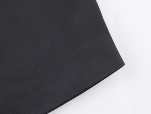 Detailed macro view of black herringbone wool fabric texture on a modern women blazer