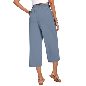 Detail of high-waisted linen trousers featuring elastic waistband and blue natural fabric