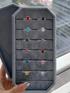 Macro view of twelve S925 sterling silver rings with colorful zircon in a gray jewelry box