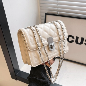 Detail of off-white quilted chain bag with silver twist-lock and woven strap