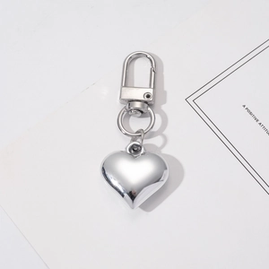 Close-up of heart-shaped silver metal keychain with D-ring clasp on white card