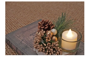 Close-up of Christmas candle holder with natural wood base, pine cones and warm LED candle