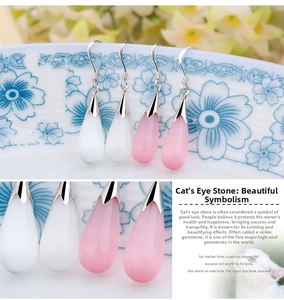 Macro shot of water-drop cat's eye earrings in white and pink with silver hooks