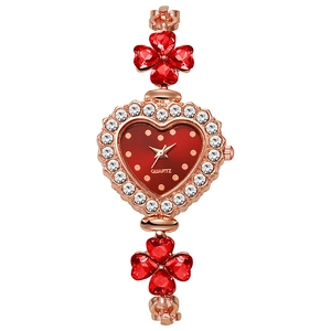 Detailed macro of rose gold heart watch featuring red clover crystal inlay and quartz dial
