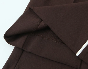 Close-up of brown knitted fabric with white side stripe and detailed flatlock stitching