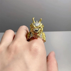 Detailed close-up of a two-tone dragon head ring with gold and silver carving details