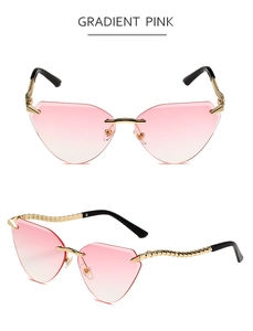 Close-up of rimless cat-eye sunglasses featuring gradient pink lenses and wavy gold temples
