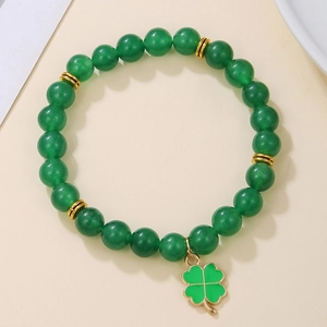 Close-up of green beaded bracelet with gold spacers and enamel four-leaf clover charm