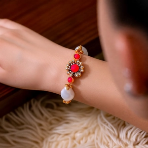 Detail eines Vintage-Blumenarmbands mit Perlen und rotem Edelstein auf Goldkette