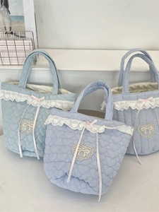 Blue heart quilted tote bag with lace edges and pink ribbon bow in a lifestyle setting