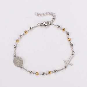 Detail of bicolored beads bracelet featuring a Virgin Mary medal and cross charm pendant