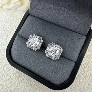 Macro shot of 6mm Asscher cut silver studs with halo diamonds in a gray velvet jewelry box