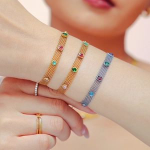 Ensemble de bracelets en maille or et argent avec zircons colorés sur un mannequin