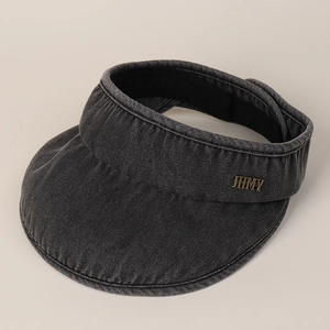 Detail of grey denim sun visor featuring metallic JHMY logo and durable fabric texture