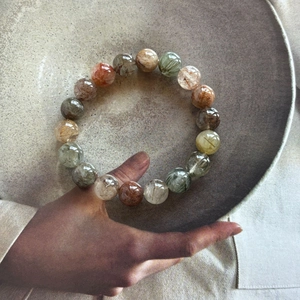 Detailed view of 10mm multicolor natural rutilated quartz beads on a creative display