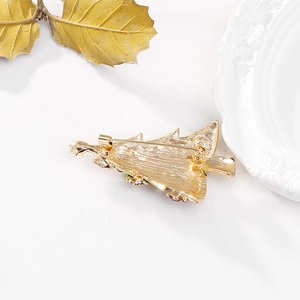 Back view of golden Christmas tree brooch showing secure safety pin and alloy structure