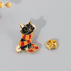 Detail of cartoon black cat enamel pin with scarf and gold butterfly clasp on back