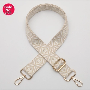 Close-up of geometric diamond pattern woven bag strap with polished gold metal hardware