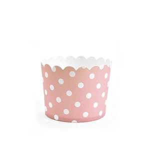 Detail of pink paper muffin cup with white polka dots and wavy edge for baking muffins