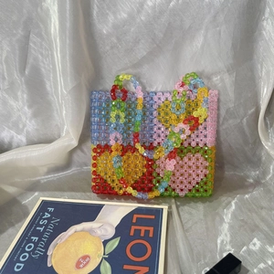 Macro detail of colorful beaded tote bag showing intricate handmade weaving patterns