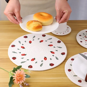 Vintage cotton woven placemat with strawberry print on a rustic wooden dining table