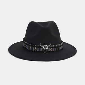 Detalle de sombrero fieltro negro con banda tejida de colores y hebilla de cráneo de toro