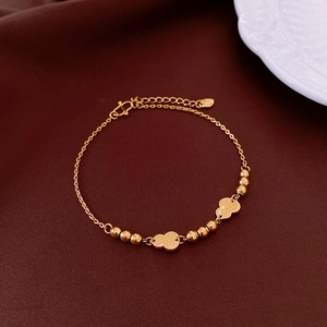 Detail of 18k gold plated bracelet featuring round beads and vintage gourd pendants