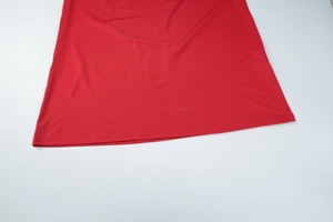 Detailed close-up of red bodycon dress hem showing smooth fabric and fine double stitching
