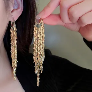 Elegant gold leaf tassel drop earrings featuring cascading metal scales in a luxury style
