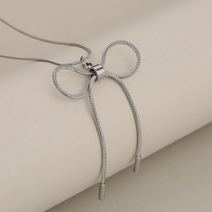 Elegant silver bow pendant on a delicate snake chain necklace with high-shine finish