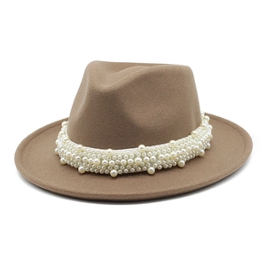 Detalle de sombrero fedora de lana camello con elegante banda decorativa de perlas