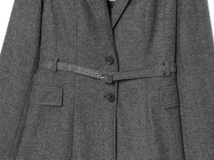 Vue détaillée du blazer en tweed gris foncé avec oeillets métalliques sur la ceinture