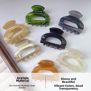 Detail showing seven colors of acetate claw clips with gold France Handmade logo