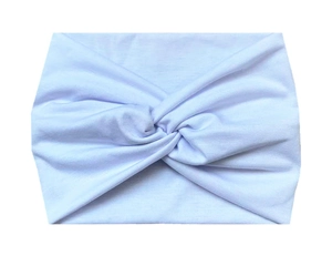 Close-up of a white knotted yoga headband featuring soft knit fabric and cross-twist detail
