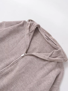 Detailed close-up of the metal zipper and knit texture on this lotus pink hooded sweater